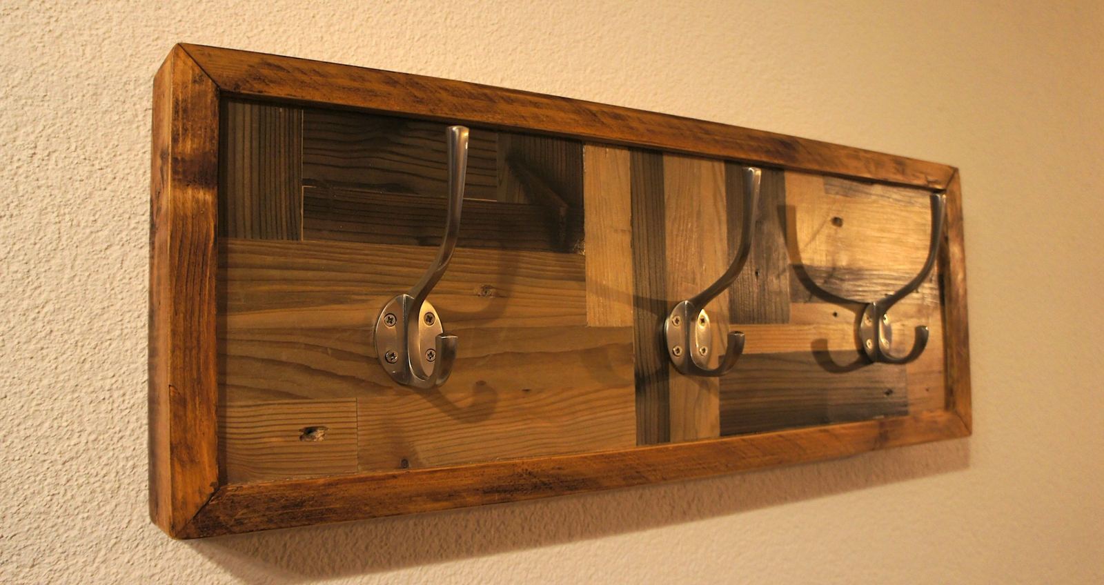 Framed coat rail with patchwork reclaimed pine boards and three steel hooks