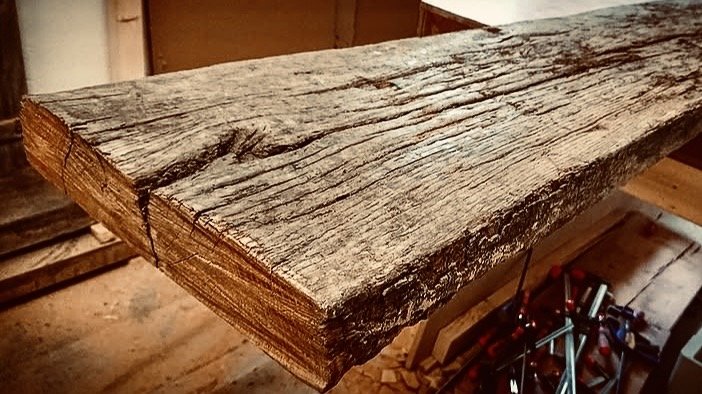 Weathered oak beam with checks and an end split, on the workbench