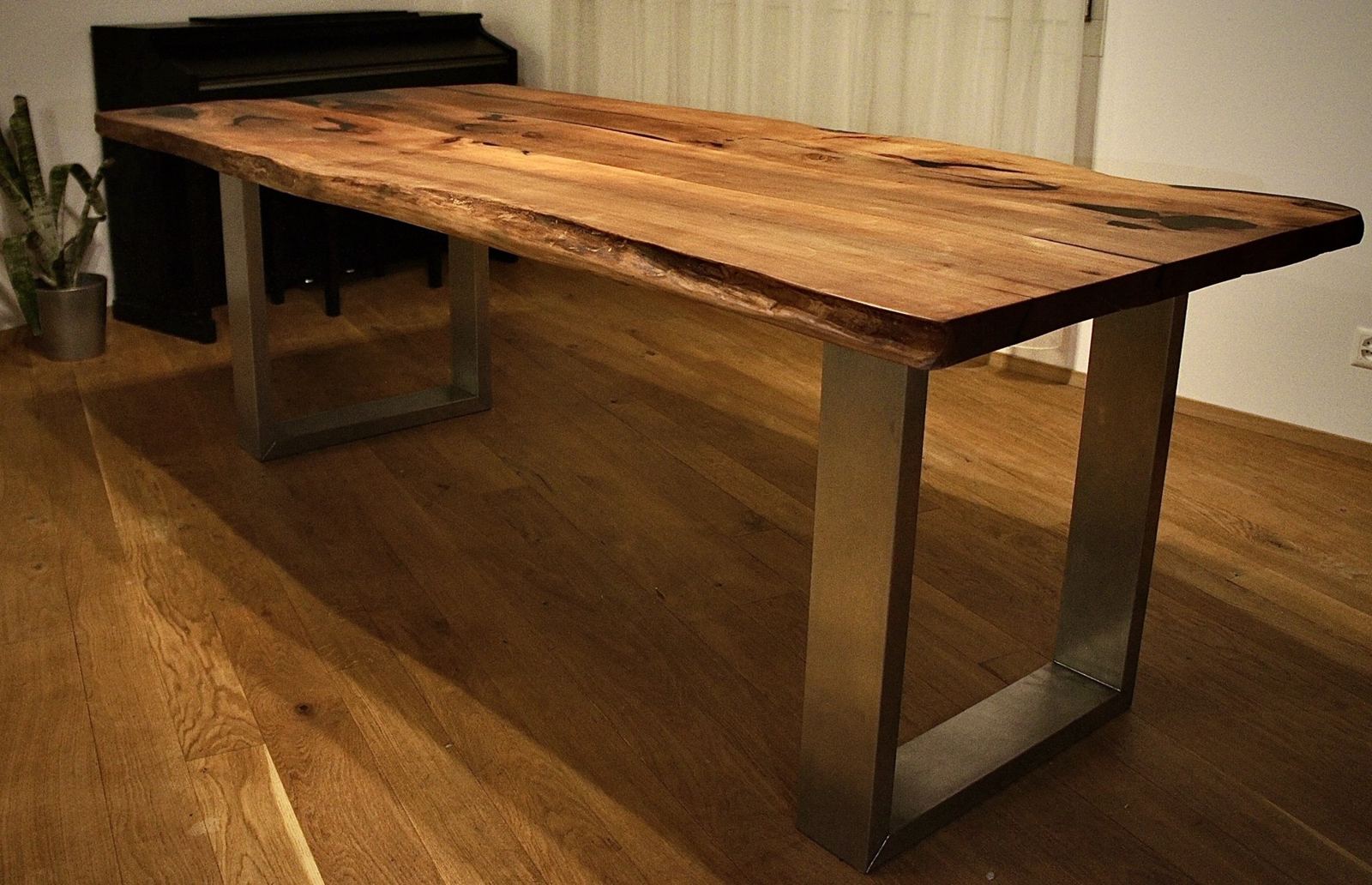 Live-edge walnut dining table on brushed steel box legs